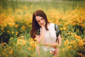 happy senior girl in a field of flowers