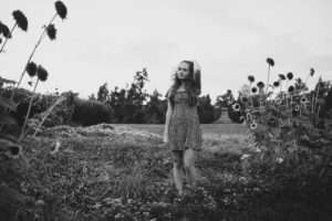 girl in flower field looking sad black and white