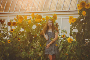 Senior girl in huge sunflower field